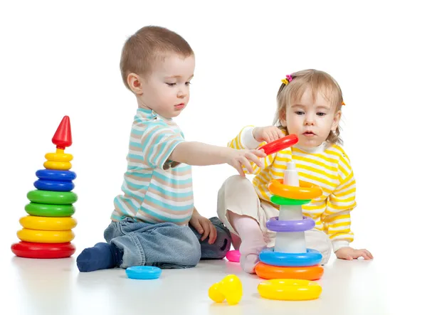 Two little children playing with color toys