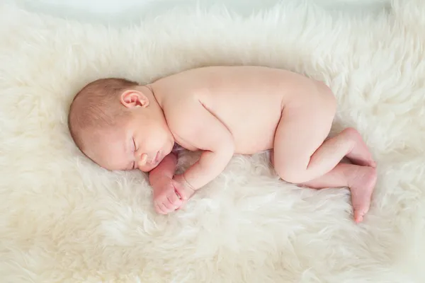 Top view of sleeping newborn baby on fur