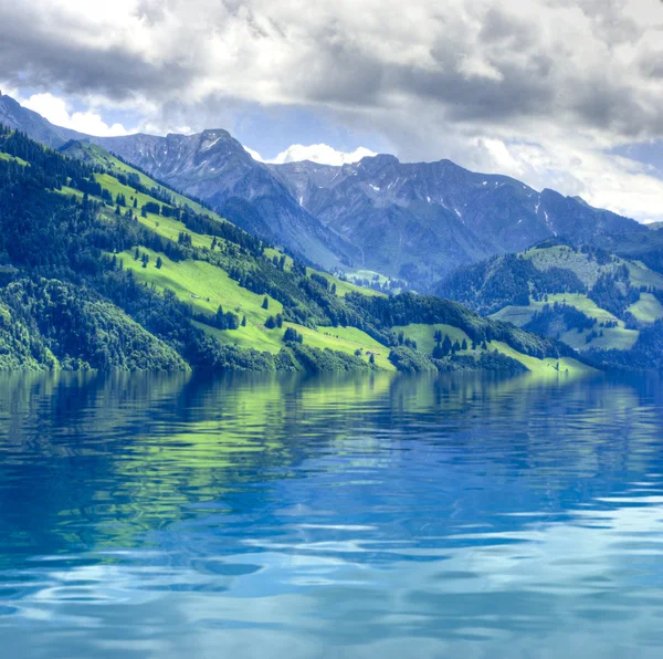 Swiss landscape. Green mountains in water reflection. Ecology