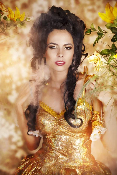 Sensual woman in long yellow dress and flowers