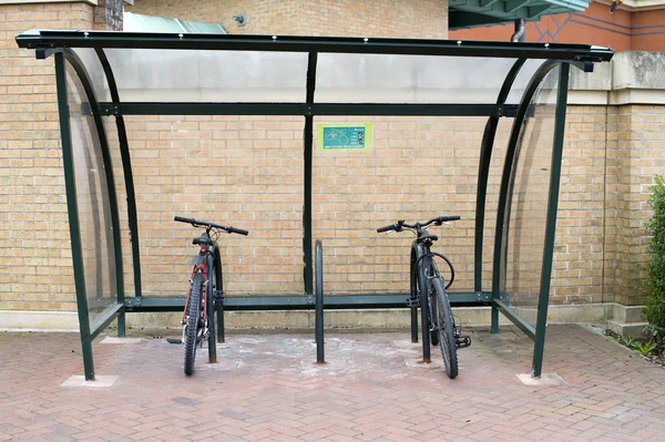 Two bikes locked to a covered bike rack
