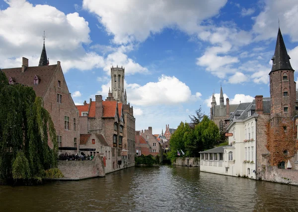 Most common view of medieval Bruges against blue cloudy skies.