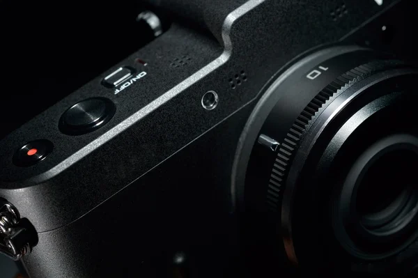 Detail of a professional digital photo camera on black background