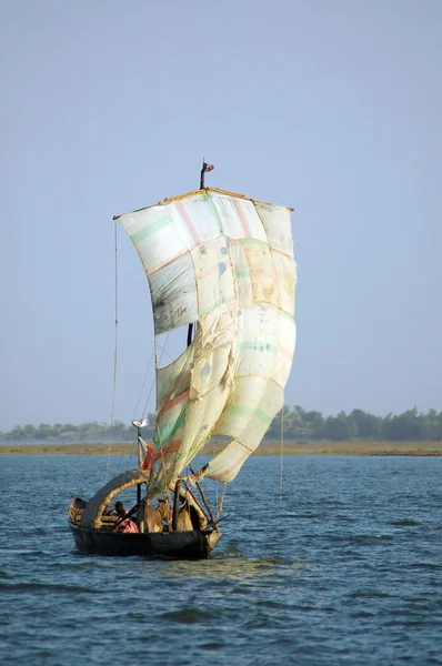 Traditional boat in West Africa with a sail