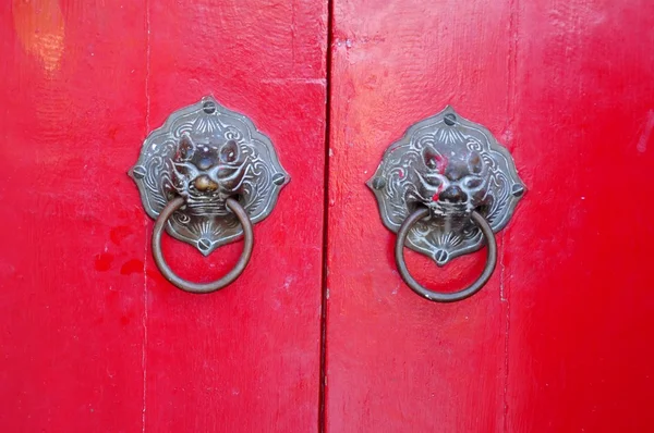 Red door decorated with golden door knobs