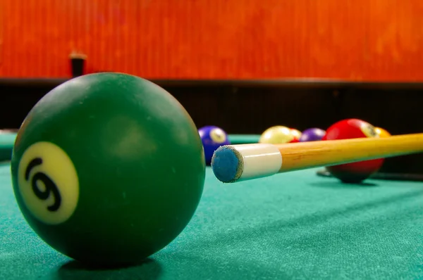 Pool table and balls shot from low angle, near ball is sharp