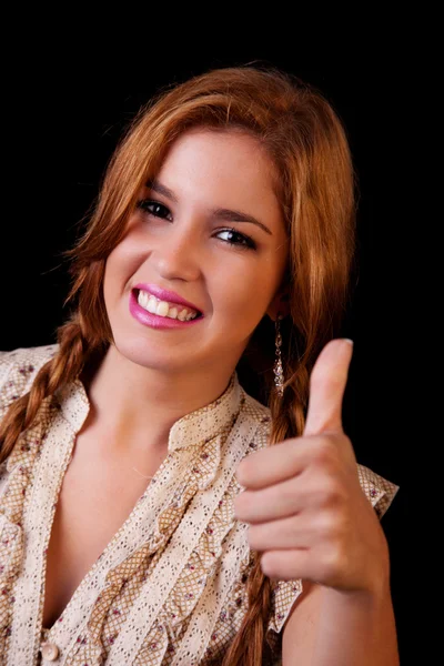 Young pretty women with thumb raised as a sign of success, thumbs up, isolated on black, studio shot