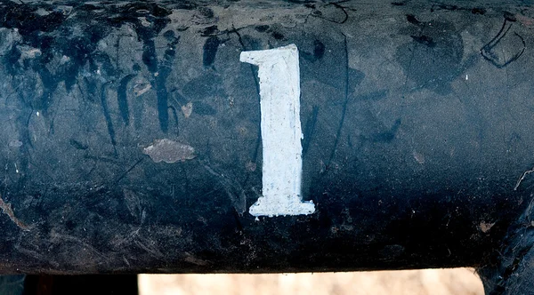 The number 1 on rusted old iron surface