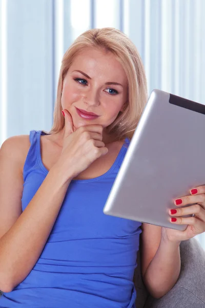 Portrait of a confident young lady reading a tablet computer