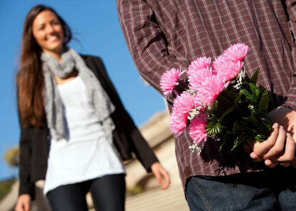 Boy surprising girlfriend with flowers