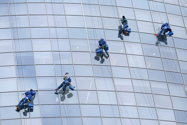 Five window cleaners on modern building