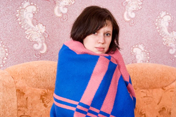 Girl fell ill and wrapped in a blanket on the couch