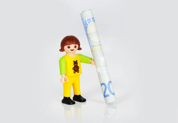 Playmobil child smiling with 20 euro banknote in her hands