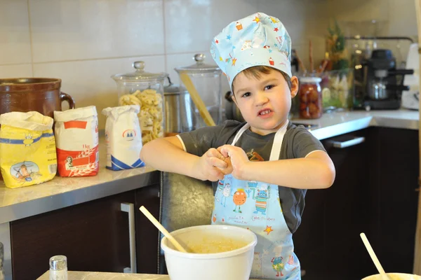 Small boy chef baking cake
