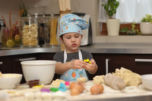 Small boy chef baking cake