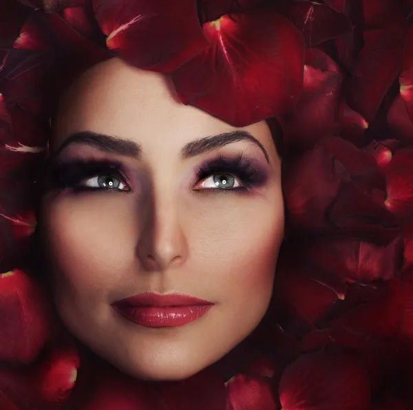 Beautiful Woman\'s Face and rose petals. Perfect Skin