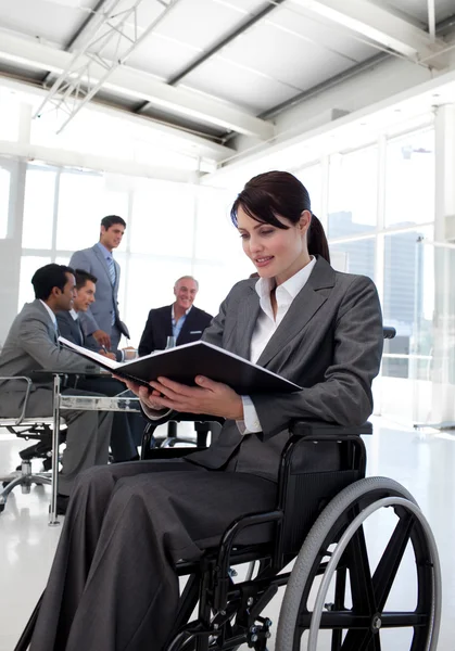 Businesswoman in a wheelchair reading a report