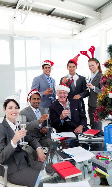 Business with novelty Christmas hat toasting at a party