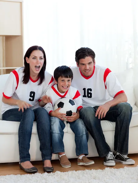Parents and their son watching a football match
