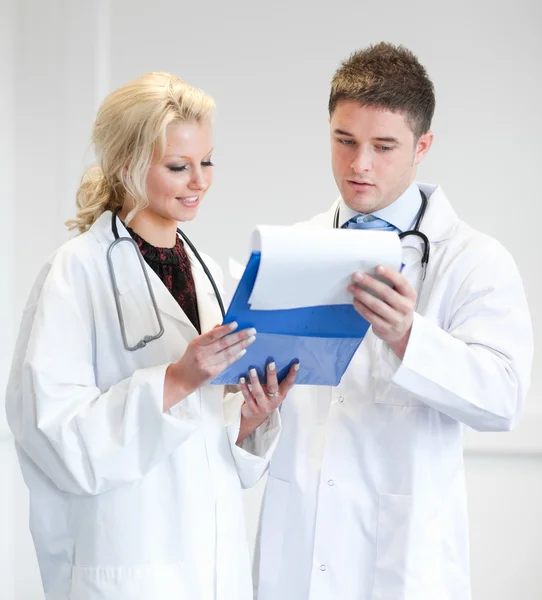 Two nice doctors looking at a report