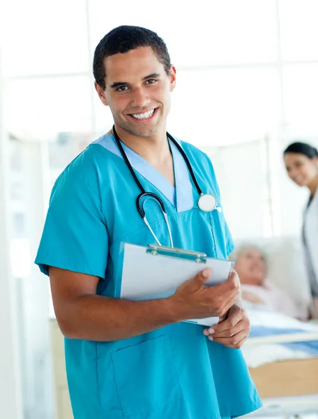 Attractive male doctor holding a medical clipboard