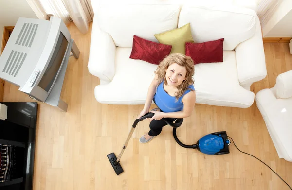 High angle of a happy woman vacuuming