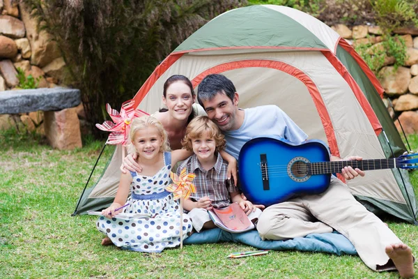 Family camping and playing a guitar