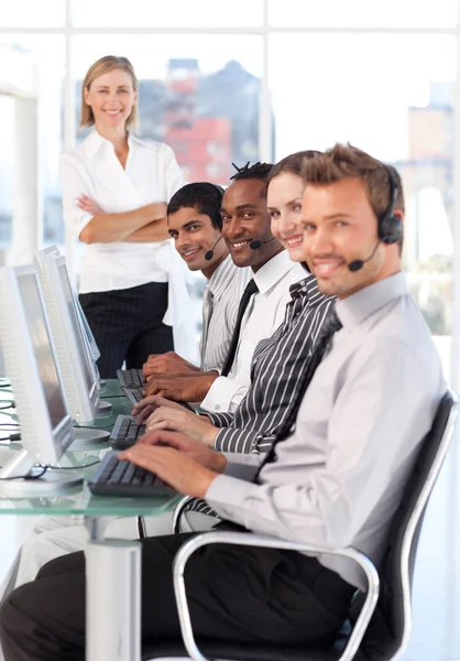Smiling female leader managingher team in a call center