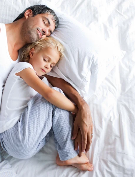 父亲和女儿睡在床上 - 图库照片Wavebreakme