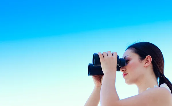 Businesswoman looking through binoculars with copy-space