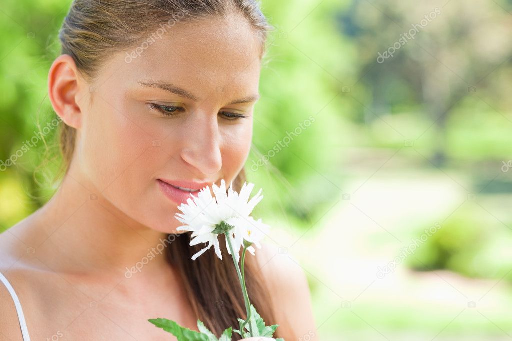genç kadın parkta beyaz çiçek kokulu — Fotoğraf sahibi Wavebreakmedia - depositphotos_10330973-Woman-smelling-on-a-white-flower-in-the-park
