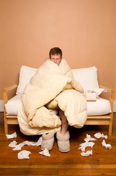 Sick man wrapped in blanket