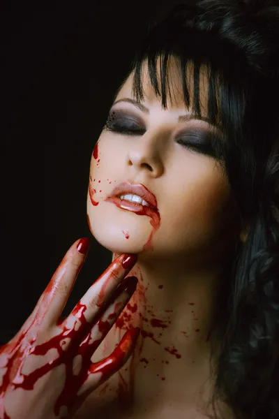 Pretty vampire woman on black background