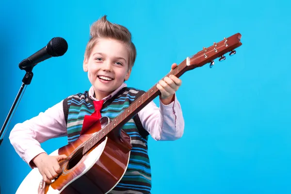 A boy with microphone and guitar