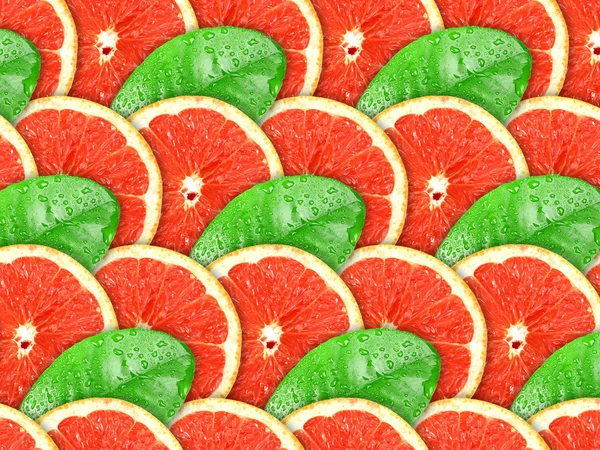 Pozadí grapefruitu řezy a zelený list — Stock fotografie
