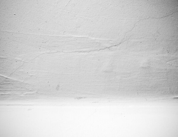 Empty white interior of cracked a stone wall