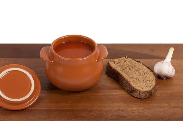 stock image Soup in ceramic pot with bread and garlic
