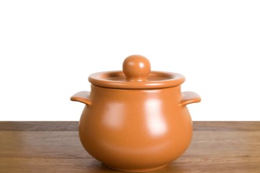 Kitchen clay pot on the wooden board clipart