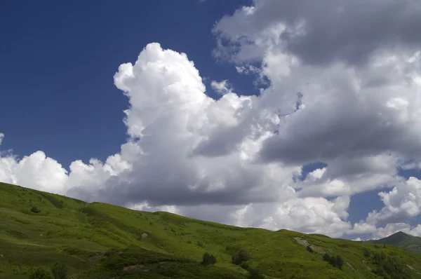 Зелений пагорб і блакитне небо з хмарами — стокове фото