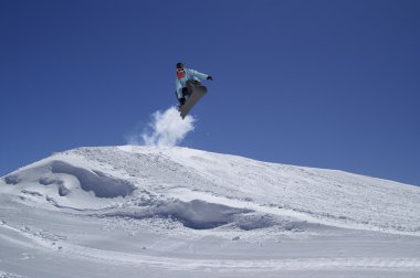 Snowboarder jumping in terrain park clipart