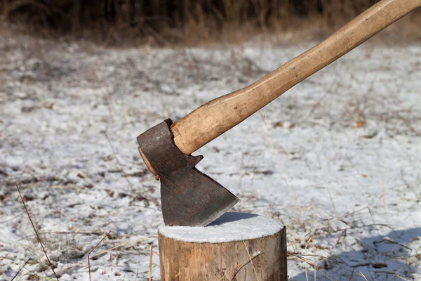 Axe and log in winter forest — Stock Photo, Image