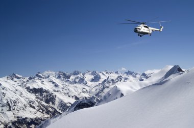 Helicopter in snowy mountains clipart