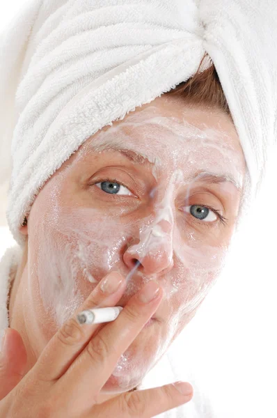 Женщина с полотенцем на голове курит — стоковое фото