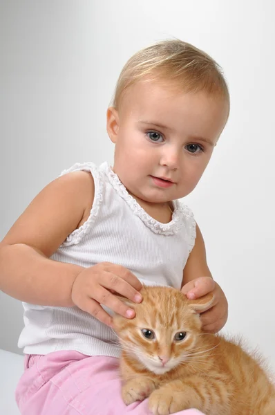 Bir yavru kedi ile oynarken bebek — Stok fotoğraf
