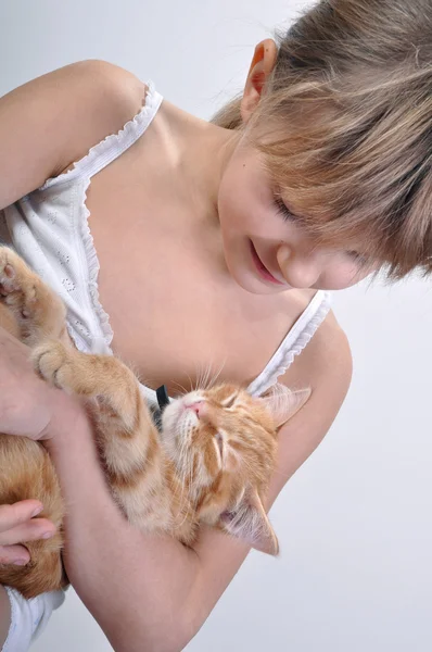 Чарівна дівчина в'їдає сплячого кошеня — стокове фото