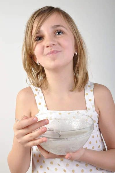 Criança feliz com uma tigela de mingau de leite — Fotografia de Stock