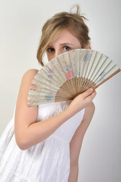 Menina bonita escondida atrás de um ventilador — Fotografia de Stock
