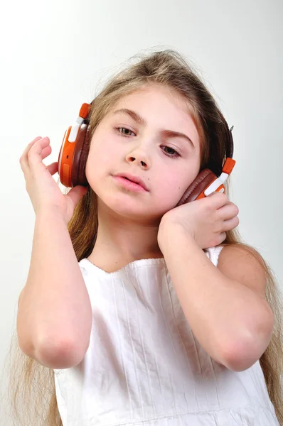 Ребенок с наушниками слушает музыку — стоковое фото