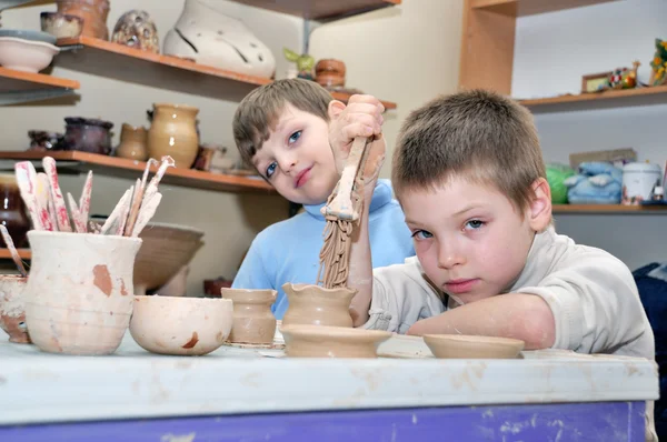Niños dando forma a la arcilla en el estudio de cerámica — Foto de Stock