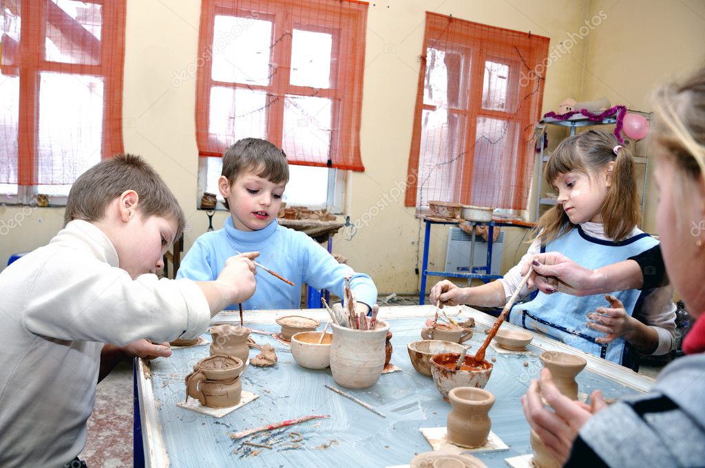 Children shaping clay in pottery studio